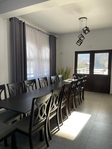 a dining room with a black table and chairs at Din Natura in Vărbilău