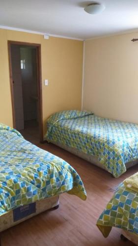 a room with two beds in a room at Hosteria y Cabañas Rucantu in Freire