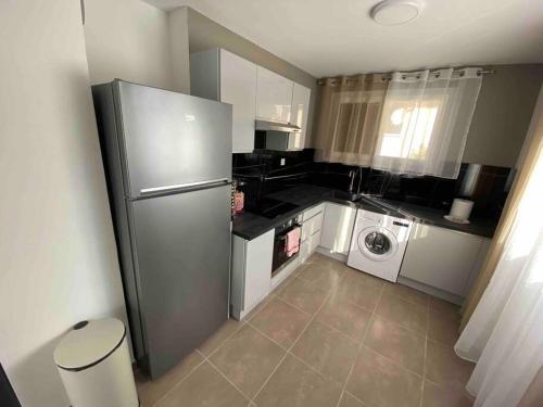 uma cozinha com um frigorífico e uma máquina de lavar roupa em Relax, élégant appartement dans maison indépendante em Gap