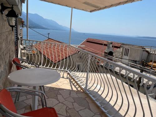 een balkon met een tafel en stoelen en uitzicht op het water bij Apartments Leut in Pisak