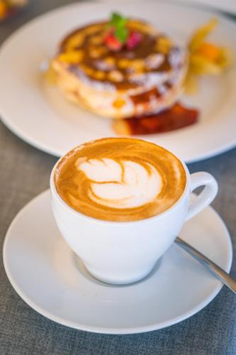 a cup of coffee on a plate with a pastry at Hotel & Spa Relais Freedom Club in Massa Lubrense