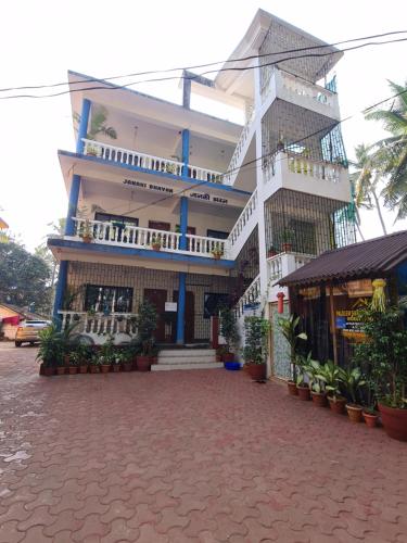 a large white building with balconies on a street at Palolem Sunrise Apartment in Palolem
