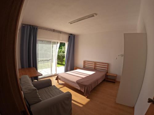 オルタにあるApartamentos Praia do Almoxarifeのベッドルーム1室(ベッド1台、ソファ、窓付)