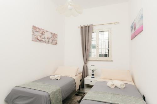 a bedroom with two beds and a window at Pescoluse Houses in Marina di Pescoluse