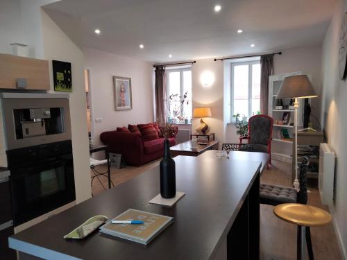 Il comprend une cuisine et un salon avec un canapé rouge. dans l'établissement Les Chambres Hautes d'Anastasia, à Rodez