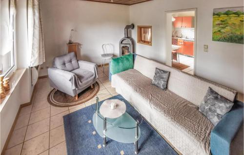 ein Wohnzimmer mit einem Sofa, einem Tisch und einem Stuhl in der Unterkunft Ferienhaus Am Hagenberg U in Stiege