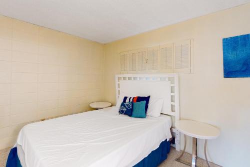 Un pequeño dormitorio con una cama blanca y una mesa en Gulf Terrace 126 en Destin