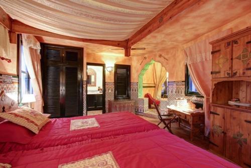 a bedroom with a large red bed and a desk at Hotel Amanhavis in Benahavís