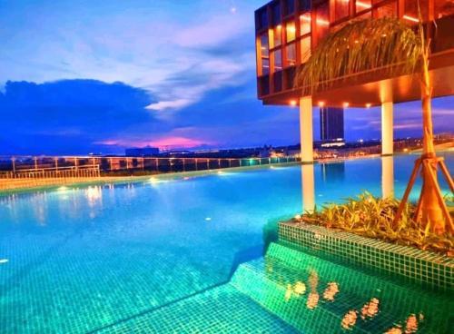 a large swimming pool at night at JRv HotelStyle HomeStay Melaka in Malacca