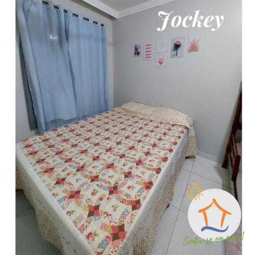 um quarto com uma cama com uma colcha em Ap Privativo Jockey, uma quadra da praia, Sentir-se em casa! em Vila Velha