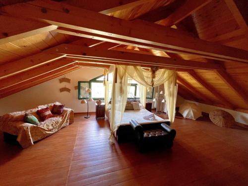 a living room with a couch and a bed in a attic at Estate Tsiati - Κτήμα Τσιάτη in Nafplio