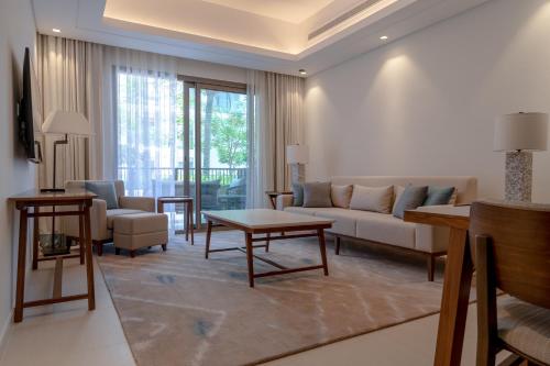 a living room with a couch and a table at Alnoon at Address Beach Resort Fujairah in Sharm