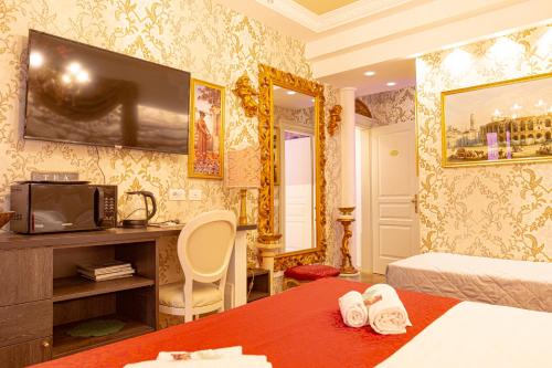 a hotel room with a bed and a television at Giardini dell'Arena Relais in Verona