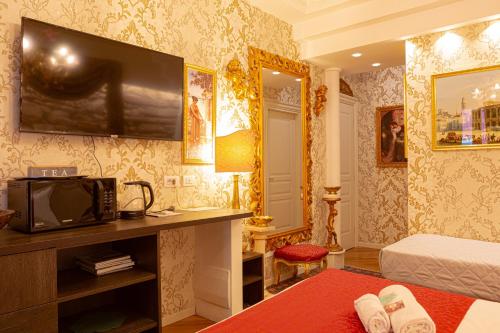 a bedroom with a bed and a tv on a wall at Giardini dell'Arena Relais in Verona