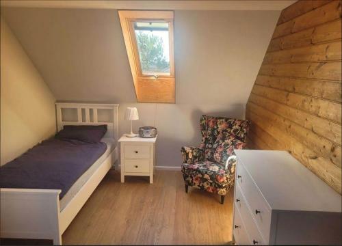 瑟薩奇的住宿－DOMEK W TRZĘSACZU，卧室配有床、椅子和窗户。