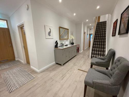 a living room with two chairs and a staircase at Cotswold Hare in Cirencester