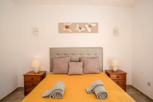 une chambre avec un lit avec deux lampes et deux serviettes dans l'établissement Casa da Tia, à Luz