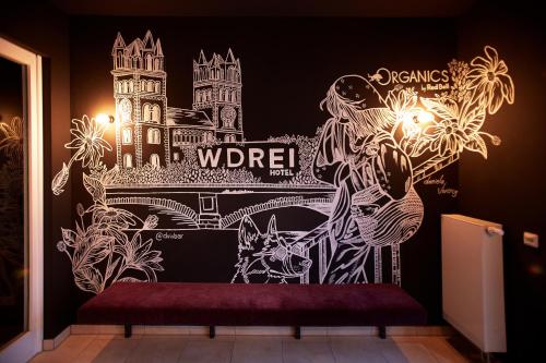 a wall mural in a room with a bench at WDREI Hotel in Munich