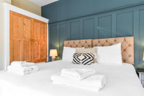 a bedroom with a large bed with towels on it at Haydn House Luxurious Retreat - 4 bedroom, 10 guest max, Perfect home away from home in Nottingham