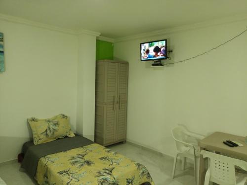 ein Schlafzimmer mit einem Bett und einem TV an der Wand in der Unterkunft LodgeFabi'sPlace in San Andrés