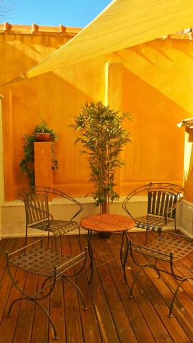 a patio with two chairs and a table with a tree at Hotel Relais Du Postillon in Antibes