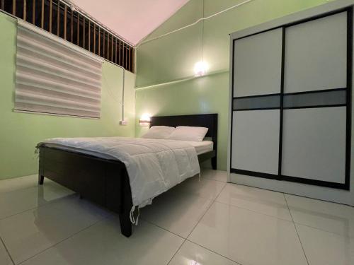 a bedroom with a bed and a large window at Papadam Bamboo House in Bintulu