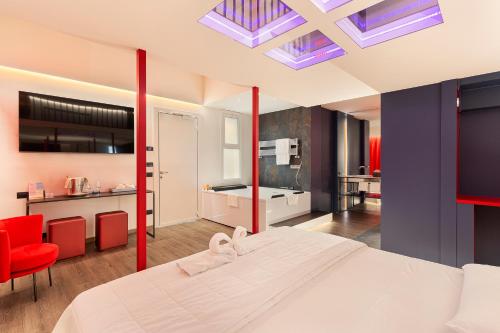 1 dormitorio con 1 cama blanca grande y sillas rojas en Motel Rona, en Caponago