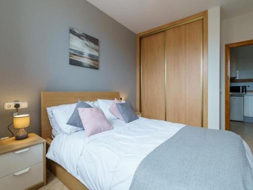 1 dormitorio con 1 cama grande con almohadas rosas y azules en Apartment La Cala Boulevard en La Cala de Mijas