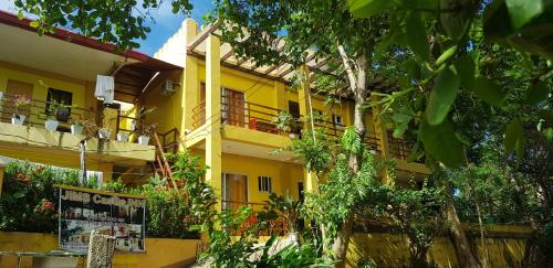 żółty budynek z balkonami i roślinami w obiekcie JIM'S CASTLE INN w mieście Coron