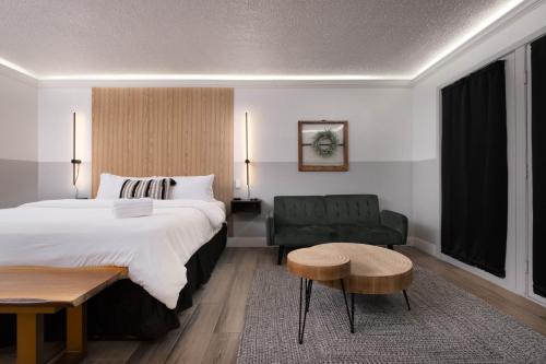 a bedroom with a large bed and a green couch at Cactus Cove Inn and Suites in Amarillo