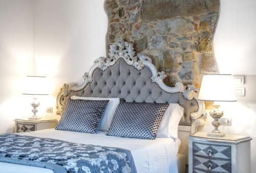 a bedroom with a king sized bed with a stone wall at Residenza le Colline del Paradiso in Bivigliano