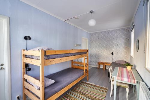 ein Schlafzimmer mit Etagenbetten in einem Zimmer mit blauen Wänden in der Unterkunft Hovra Vandrarhem in Korskrogen