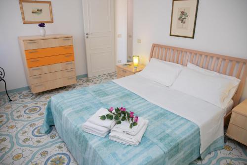 a bedroom with a bed with towels and flowers on it at Talè Talè Apartment in Marina di Ragusa