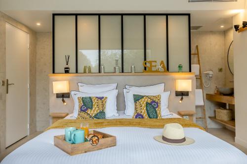 a bedroom with a large bed with a hat on it at Le Lodge des Îles d'Or in Hyères