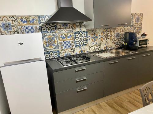 a kitchen with a stove and a white refrigerator at Joya house in Taranto