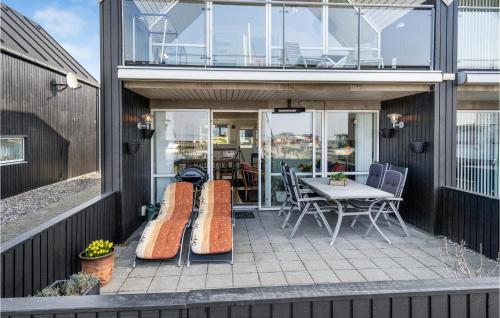 a patio with a table and surfboards on it at Two-Bedroom Holiday Home In Tranekar in Lohals