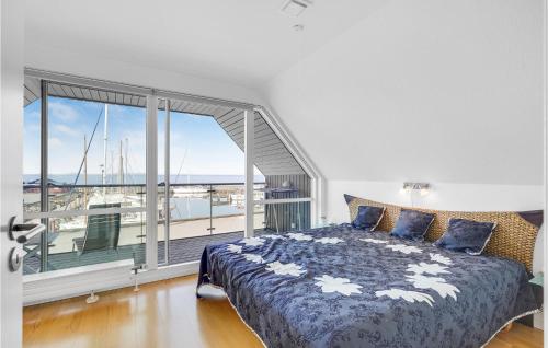 a bedroom with a bed and a large window at Lovely Home In Tranekr With House Sea View in Lohals