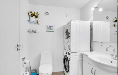 a white bathroom with a sink and a refrigerator at Lovely Home In Tranekr With House Sea View in Lohals