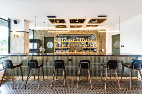 un bar con sgabelli neri in una stanza di Owen House by Habyt a Singapore