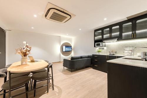 a kitchen and living room with a table and chairs at Owen House by Habyt in Singapore