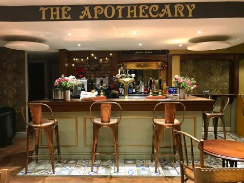 un bar en un restaurante con cuatro taburetes en The Glen Mona Hotel en Maughold