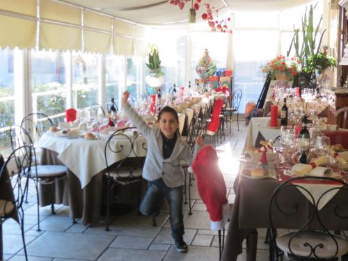 a young child is standing in a room with tables at Hotel Ristorante Eurossola in Domodossola