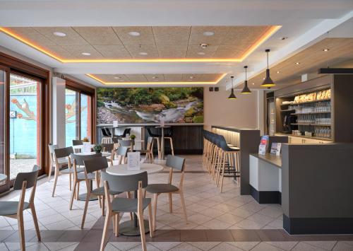 a restaurant with tables and chairs and a bar at Youth Hostel Larochette in Larochette