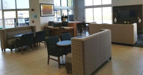 a restaurant with tables and chairs and windows at Holiday Inn Express Madera by IHG in Madera