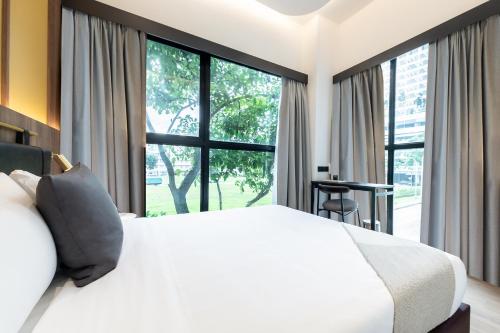 a bedroom with a white bed and a large window at Owen House by Habyt in Singapore