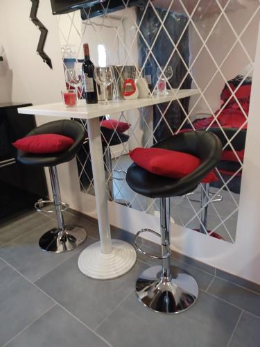 a bar with two stools and a table with wine bottles at Aquas AP in Petrijanec