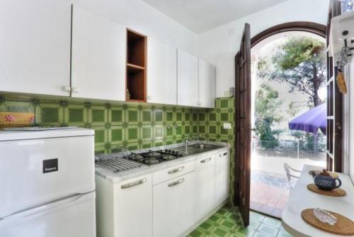 a kitchen with white appliances and green tiles at Capoliveri: Villa Artistica app. 2/bilo4 (bilocale in Capoliveri