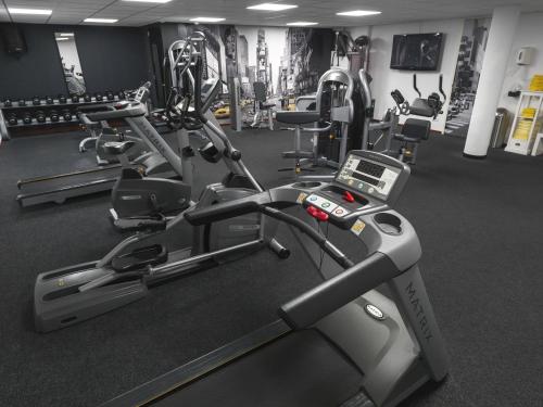 - une salle de sport avec plusieurs tapis de course et appareils de cardio-training dans l'établissement Hotel Bornholm, à West-Terschelling