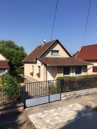 uma casa com um portão em frente a uma casa em Százszorszép Vendégház em Mezőkövesd