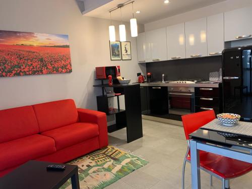 a living room with a red couch and a kitchen at CasaBella Inalpi Arena in Turin